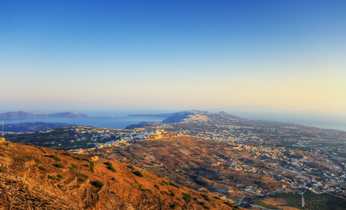 Dusk light over the Santorini caldera rim seen from the water during a catamaran boat tour, Greece