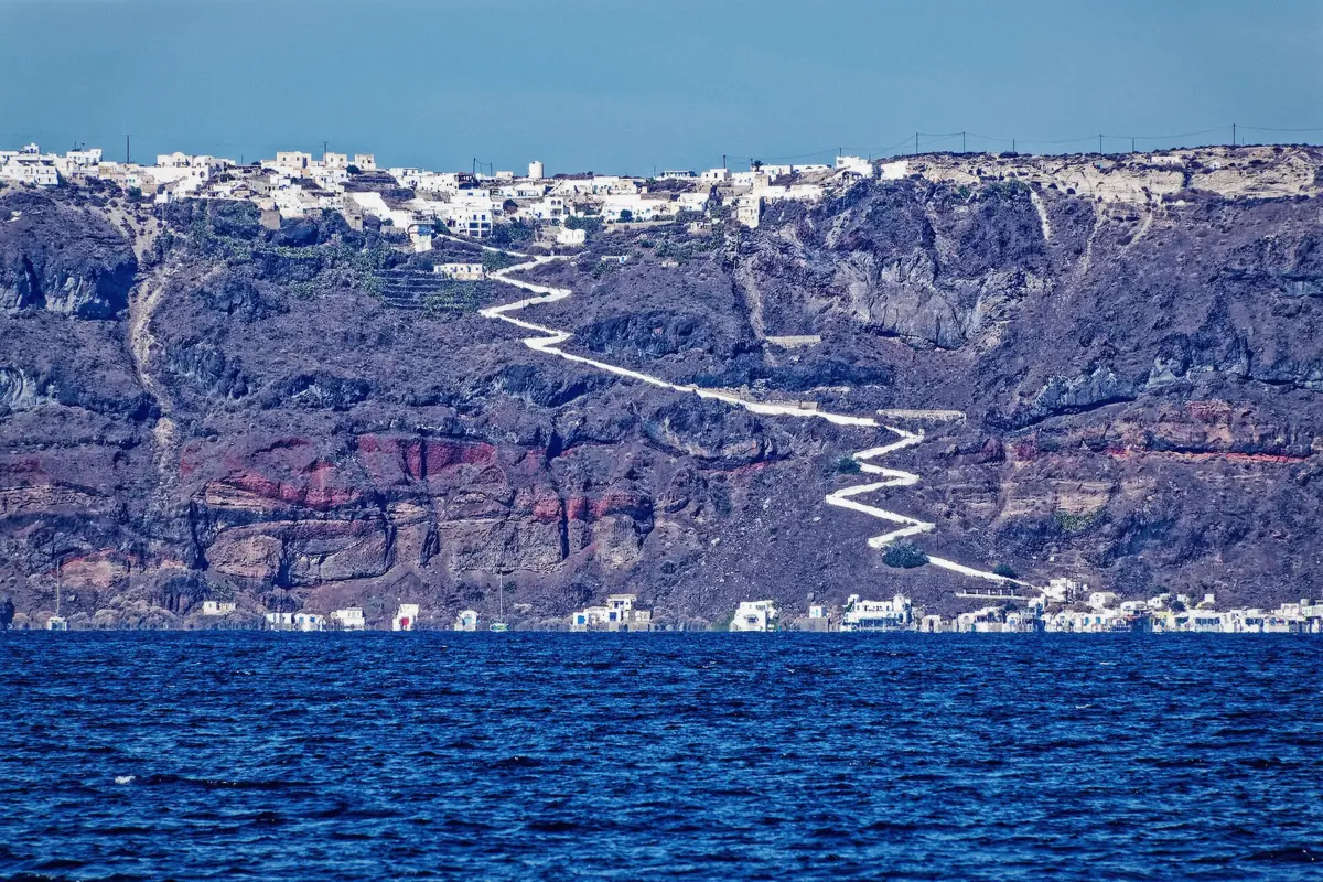 The island of Thirassia across the caldera water reached on a Santorini volcano and hot springs boat tour, Greece